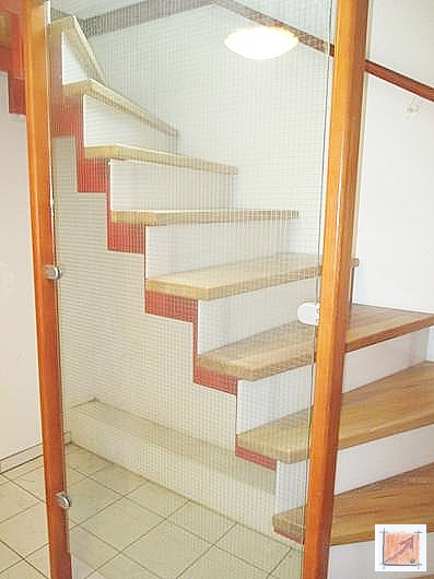 Handwerkliche Höchstleistung: Transparente Sicherheit durch ESG-Glas und edle Rüster-Hölzer. Moderne Metalltreppe mit Tritten aus Rüster-Holz und einem transparenten Geländer aus ESG-Sicherheitsglas im Holzhaus.