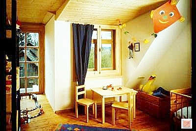 Vermögenswerte bewahren: Edler Holz-Innenausbau geschützt durch präventive Technik. Hochwertiges Wohnzimmer-Interieur mit massiven Kirschbaumholz-Decken unterhalb der Nasszelle (Bad).