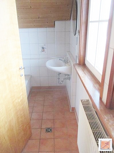 Prävention durch Entwässerung: Der Bodenablauf als Sicherheitsfaktor für das Vermögen. Strategisch platzierter Bodenablauf in einem Badezimmer im Holzhaus zur Sicherung der Bausubstanz.